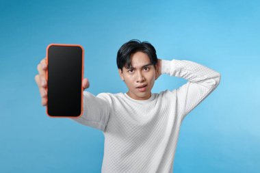 Zeki telefonun yeşil ekranını gösterirken gülümseyen Asyalı genç adamın vay haline.