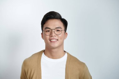 Genç yakışıklı Asyalı adamın açık arkaplanda yakın plan portresi.