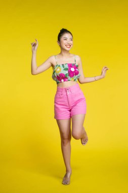 Tek ayak üzerinde duran neşeli kadının uzun bir görüntüsü.