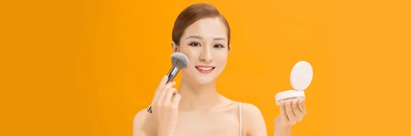 バナーの背景にメイクブラシを使用して顔に乾いた化粧品のトーナルの基礎を適用するアジアの女性 — ストック写真