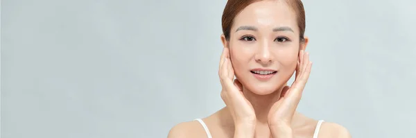 アジアの女性は素敵な顔を持っています彼女の完璧な肌に触れて幸せを感じています バナー — ストック写真