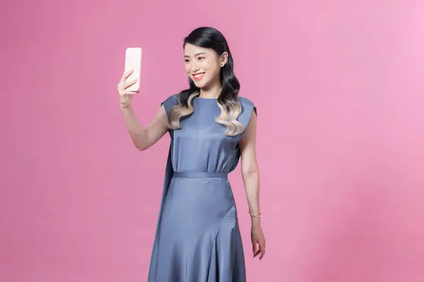 Uśmiechnięta Elegancka Kobieta Jedwabnej Sukience Telefonu Komórkowego Różowym Tle — Zdjęcie stockowe