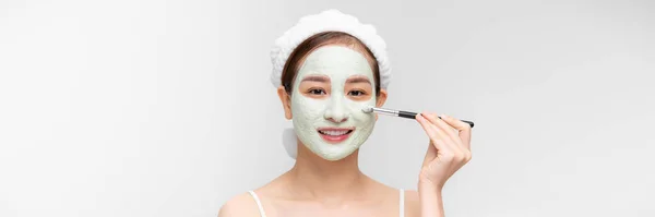 快乐的年轻亚洲女人用刷子在脸上涂上了白色的面具 — 图库照片