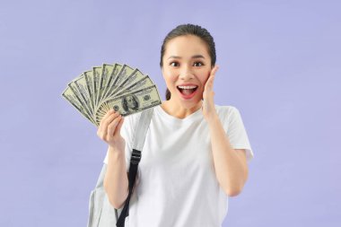 Sırt çantalı genç bir kadın nakit paranın hayranı.