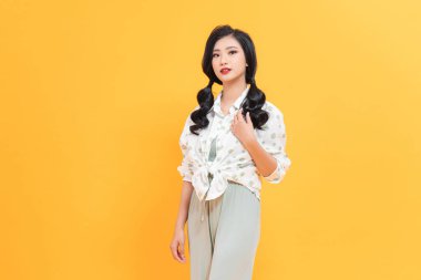 Mutlu genç Asyalı kadının iki örgülü gülüşü var.