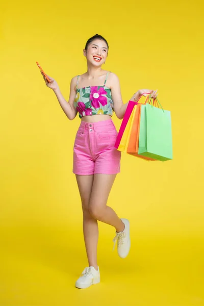 カラフルなショッピングバッグとスマートフォンを保持している自信のあるファッショナブルな若いアジアの女性 — ストック写真
