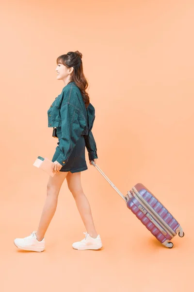 带着手提箱带着彩色背景旅行的女孩 — 图库照片
