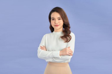 Genç Asyalı kadın izole edilmiş renkli arka planda kollarını önde kavuşturuyor.