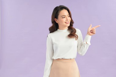 Elindeki bir şeyi gösteren ve işaret eden güzel bir kadın.