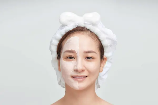 彼女の頭にタオルを持つ女性のバナーは 彼女の顔にクレンジング粘土マスクを適用します — ストック写真