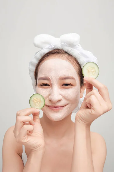 漂亮的年轻女子 脸上戴着面具 手里拿着几片新鲜黄瓜 — 图库照片