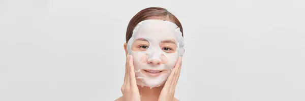 Woman Applying Sheet Mask Her Face White Banner — Stock Photo, Image
