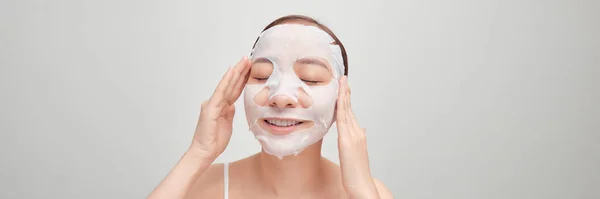 Woman Applying Sheet Mask Her Face White Banner — Stock Photo, Image
