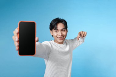 Gülümseyen adam elinde bir akıllı telefon tutuyor ve parmağını boş bir ekranda gösteriyor. 