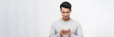 Beyaz arka planda izole edilmiş cep telefonu kullanan gülümseyen genç adam görüntüsü