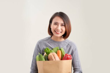 sağlıklı yaşam tarzı yeşil vegan gıda ile. genç kadın alışveriş çantası ile Sebze tutun.