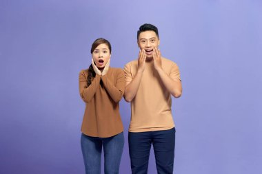 Geniş ağızlı ve avuç içlerini yanaklarına yaklaştıran iki genç şaşırmış, funky aşıklar.