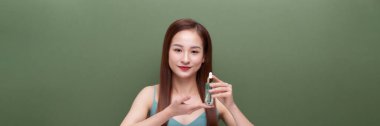 Gülümseyen kadın yeşil pankarta Argan yağı sürüyor.