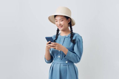  Güzel Asyalı bayan mesaj okuyor ve gülümsüyor, cep telefonu kullanıyor.