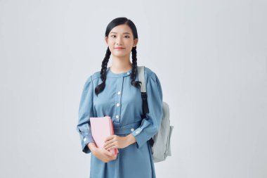 Genç bayan. Sırt çantası ve defteri beyaz arka planda izole edilmiş.