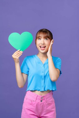 Neşeli insan portresi, kalp kartpostalı, dişlek gülümseme, menekşe rengi arka planda izole.