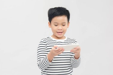 Beyaz arka planda akıllı telefonla oynayan duygusal küçük çocuk.