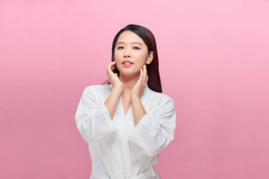 Genç bir kadının güzel yüz portresinin pankartı yanağına yüz kremi sürüyor..