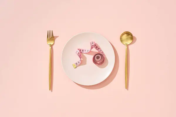 Rulla Mittanauha Vaaleanpunainen Ruokapöytä Lusikalla Haarukka Vaaleanpunainen Tausta — kuvapankkivalokuva
