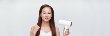 Beyaz arka planda saç kurutma makinesi kullanan Asyalı genç kadının afişi.