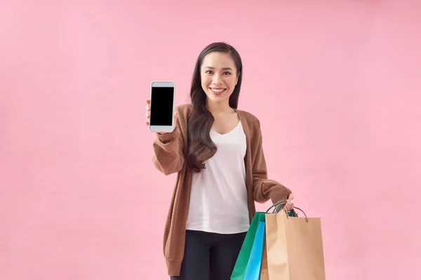 Азиатская Женщина Держит Сумки Покупками Показывает Экран Мобильного Телефона Розовом — стоковое фото