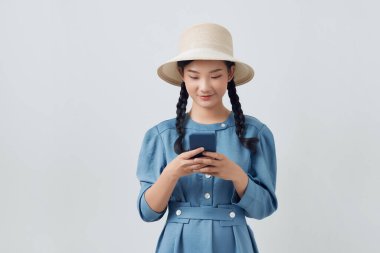 Portrait of smiling Asian woman using a smartphone isolated on white background