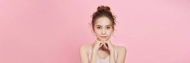 Portrait of beauty asian woman with fair perfect healthy glow skin hand touching chin on pink background