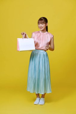 Excited smile Asian woman looking mobile phone holding shopping bags show credit card payment banking shopping online