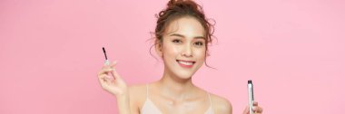 Beautiful woman with dark eyebrows hold eyebrow brush.