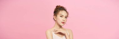 Portrait of attractive young woman over pink background