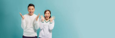 Portrait of beautiful young expressing  couple. Isolated on turquoise banner