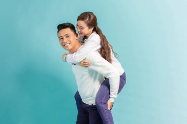 Young beautiful couple isolated on light blue background