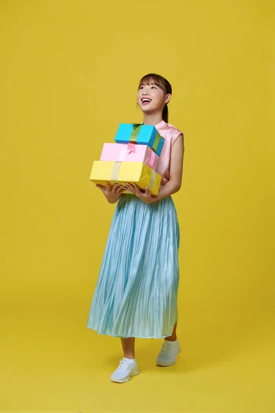 Attractive Young Girl Dress Holding Stack Gift Boxes Isolated Yellow — Zdjęcie stockowe