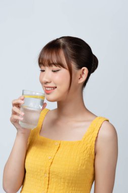 Vitamin iğnesi. Çekici Asyalı kadın bardaktan limonla maden suyu içiyor.