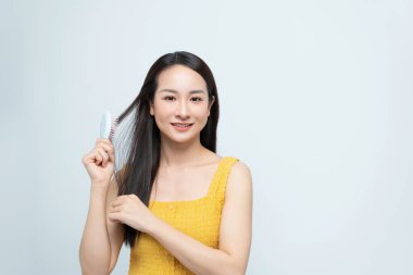 Saçlarını tarayan çekici bir kadın. Güzel kız saçını tarar. Saç bakım konsepti.