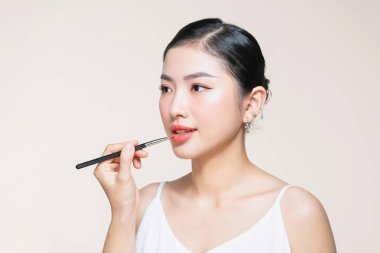 Kadın dudaklarına ruj sürerek vize uygulamasını kapat.