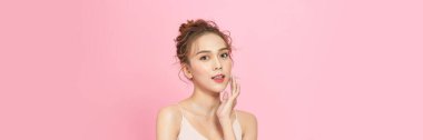 Beauty head shot of young asian woman on pink pastel background