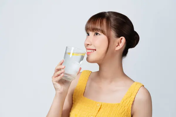 Junge Asiatin Genießt Gesundes Getränk Für Schöne Haut Und Immunität Stockbild