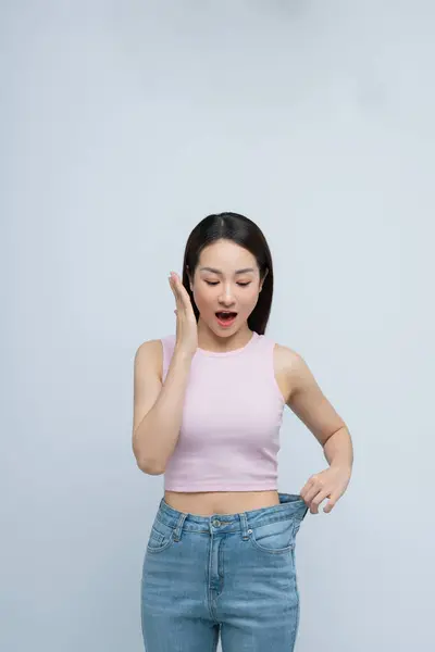 Erfolgreiche Gewichtsabnahme Asiatische Frau Mit Großen Jeans Nach Effektiver Ernährung lizenzfreie Stockbilder