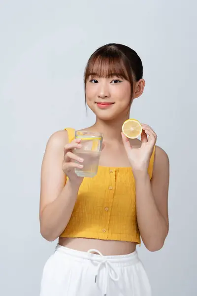 亚洲女人有半个柠檬维生素健康美容白底 免版税图库照片