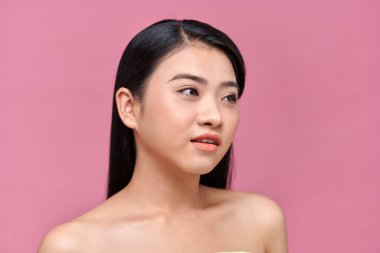 Pembe arka planda temiz ciltli güzel Asyalı bir kadın.