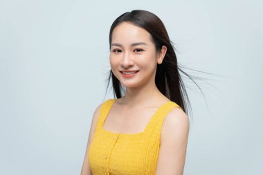 Gözleri kapalı genç bir kadın, rüzgarın saçlarında esmesiyle huzurlu ve mutlu bir anın tadını çıkarıyor..