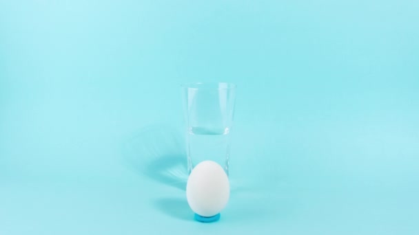 Junto Vaso Medio Lleno Aparecen Dos Huevos Con Una Expresión — Vídeos de Stock
