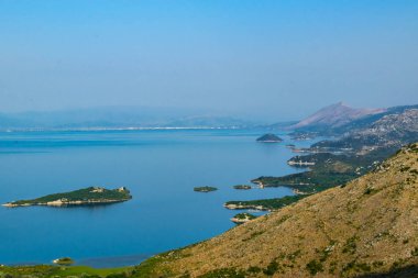 Shtegvashe Bakış Açısı. Arnavutluk sınırı yakınlarındaki Skadar Gölü 'nün küçük yeşil adaları ve mavi sularından oluşan güzel bir yaz manzarası. Açık mavi gökyüzü. Karadağ. Seyahat kavramı.