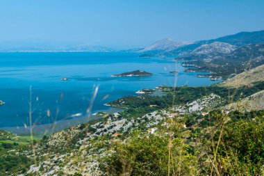 Bakış açısı Donji Murici. Arnavutluk sınırı yakınlarındaki Skadar Gölü 'nün küçük yeşil adaları ve mavi sularından oluşan güzel bir yaz manzarası. Açık mavi gökyüzü. Karadağ. Seyahat kavramı.